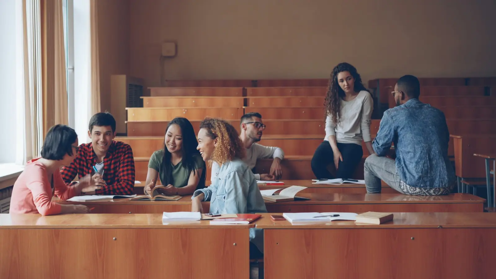 Students in conversation in a tiered lecture hall
